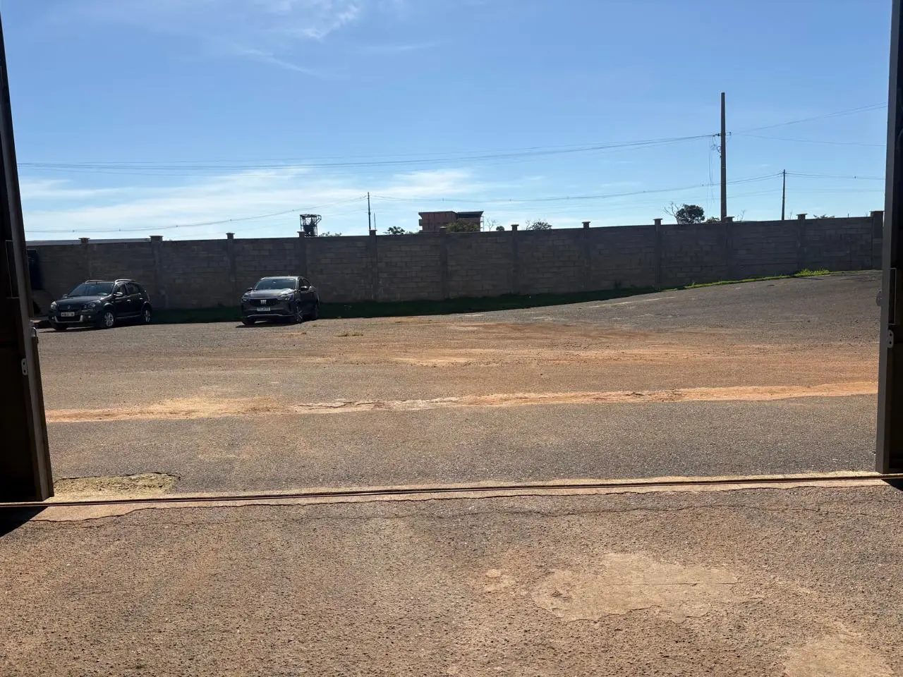 Pátio murado visto a partir do portão do galpão